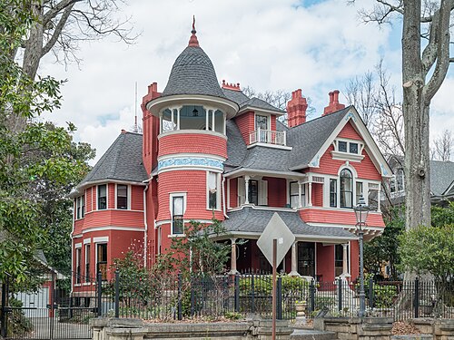 The Beath-Dickey House on Euclid Avenue, a red Queen Anne with fish scale shingles, a round turret under a conical roof and a wraparound porch, behind an iron fence on a stone kerb wall.