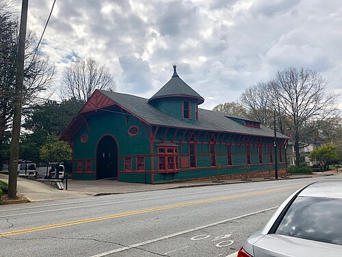 The Trolley Barn on Edgewood Avenue seen from across the street, a long dark green timber shed with red trim and a shingled turret over the middle of it.