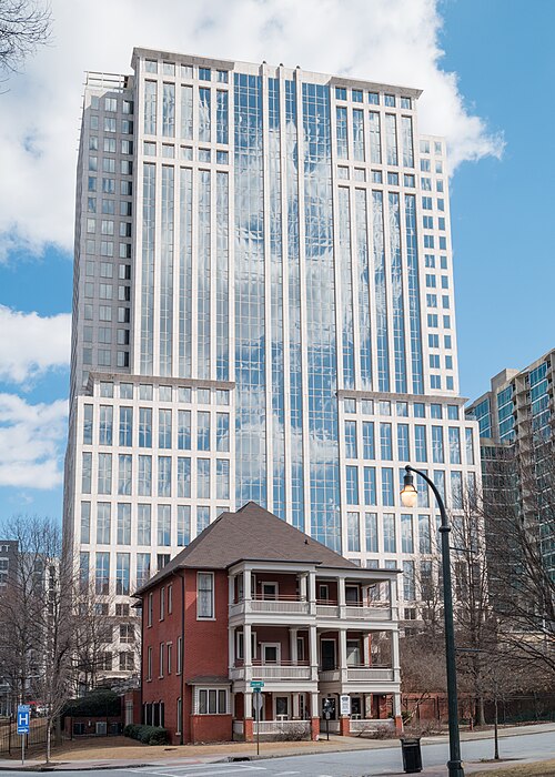 The Margaret Mitchell House, a small red brick Victorian building, with the glass tower at 999 Peachtree rising directly behind it.