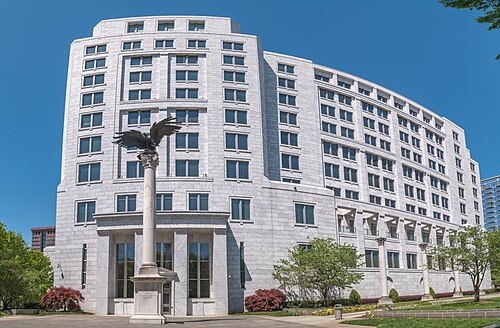 The Federal Reserve Bank of Atlanta building, a curved white stone facade with a column and eagle sculpture on the plaza in front.