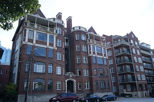 The Palmer House and Phelan House Apartments, a Tudor style brick apartment building with turrets and balconies, a glass tower visible behind it.