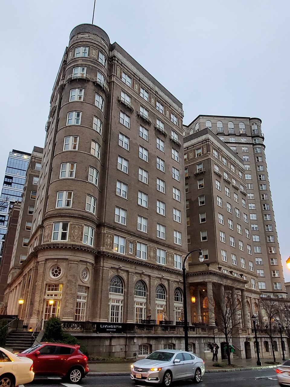 The Georgian Terrace Hotel seen from across Peachtree Street, its curved corner tower and a taller glass addition rising behind it.