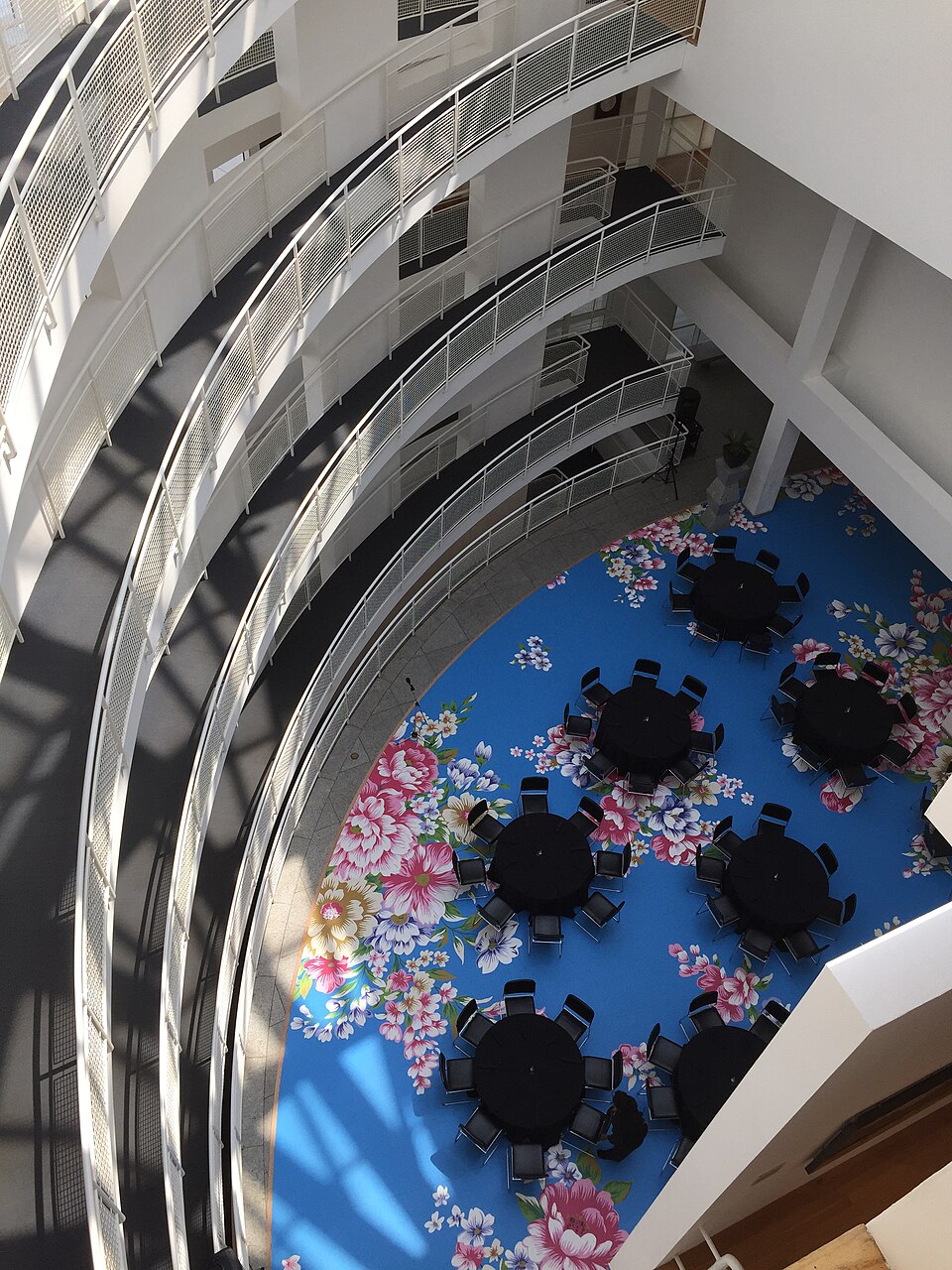 The Nita and J. Mack Robinson Atrium inside the High Museum of Art, curved white catwalks and skylights above a tiled floor.