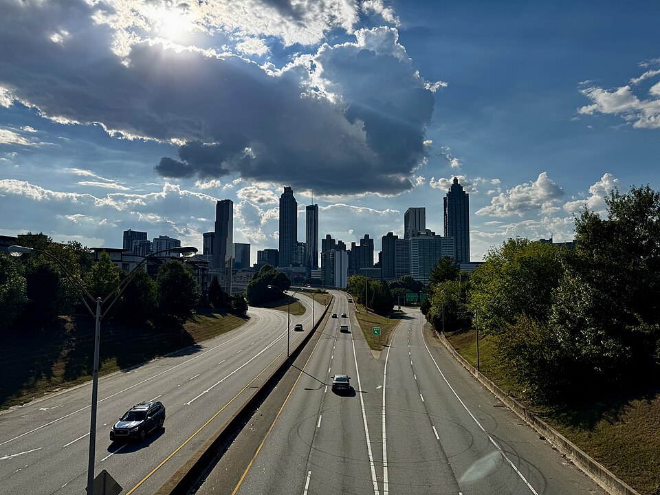The view west from the Jackson Street Bridge, Freedom Parkway running down toward downtown with a handful of cars on it and the skyline in the middle of the frame.
