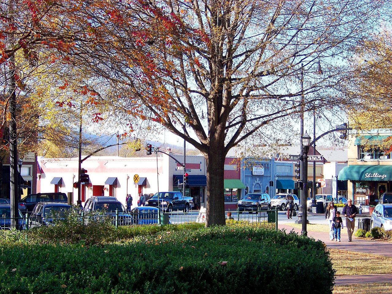 Marietta Square in the fall, park benches and brick paths in the foreground and a row of two story storefronts across the street.