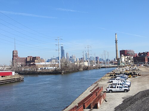 The Sanitary and Ship Canal at Loomis Street, truck yards along the bank and the downtown skyline across the water.