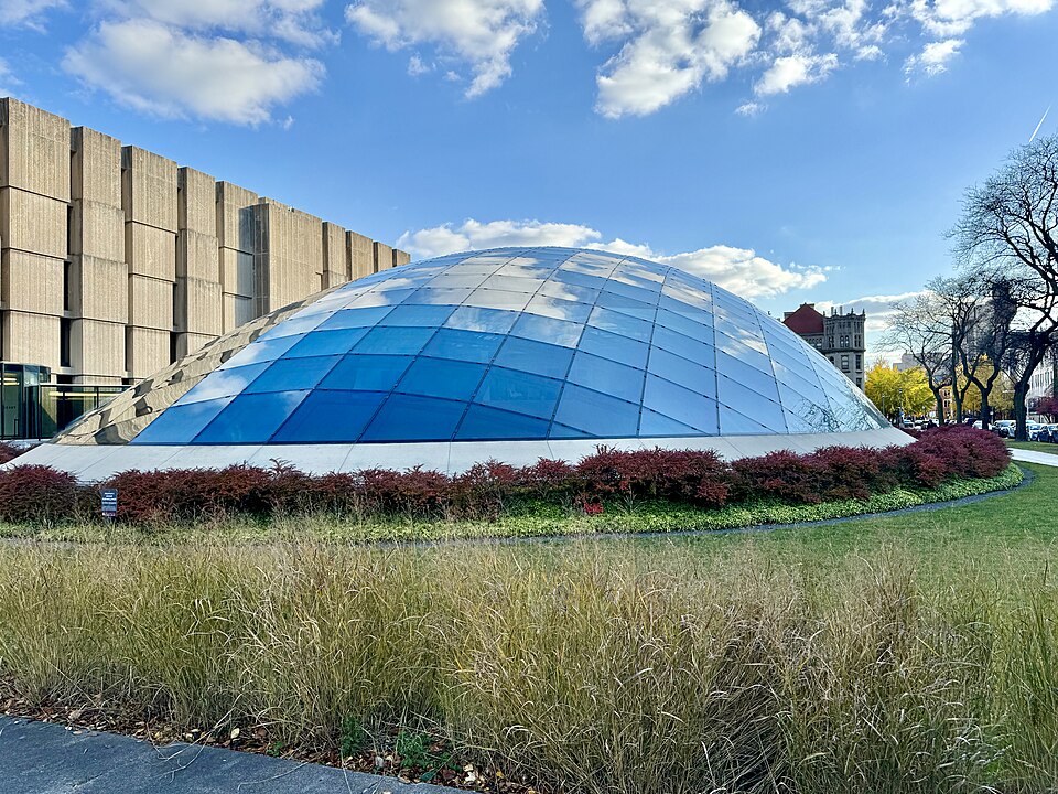 The Mansueto Library's elliptical glass dome over a lawn, the Regenstein Library's concrete block behind it.