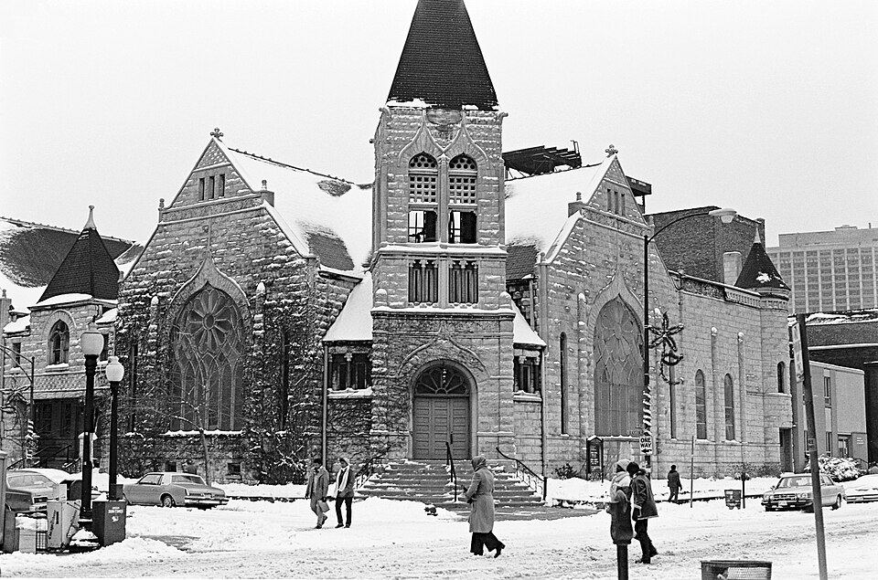 The United Church of Hyde Park under snow in 1978, its corner bell tower and rose window over the sidewalk.