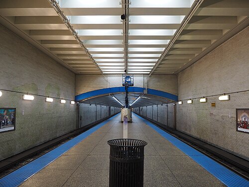 The underground platform at the Blue Line station, tiled walls and a coffered concrete ceiling running the length of the tunnel toward the Spaulding entrance.
