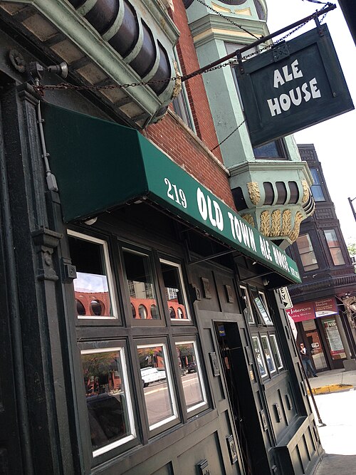 The Old Town Ale House sign and green awning over a corner storefront, ironwork trim on the building above.