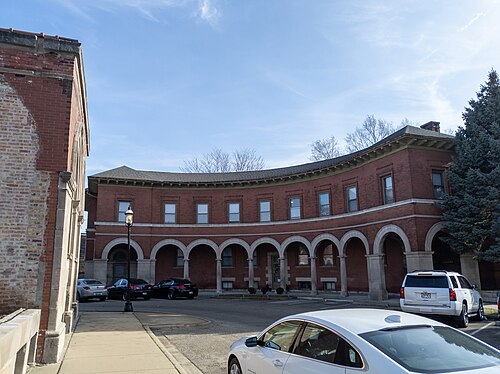 Market Square's curved brick building, a run of stone arches along its ground floor arcade facing a paved court.