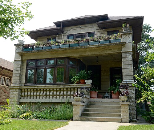 The Hanson House on Ridgeland Avenue, a foursquare house in rusticated concrete block with wide eaves and a carved balustrade along the porch and balcony.