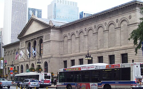 The Art Institute of Chicago's limestone Classical Revival facade on Michigan Avenue, with buses passing on the street below.