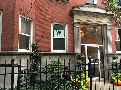 The carved stone entrance of a courtyard apartment building named The North Shore, fluted pilasters and an arched pediment over the door.
