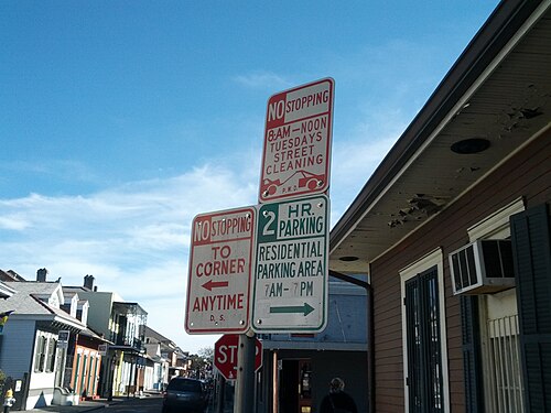 Three parking signs on one pole, street cleaning on Tuesday mornings and two hour residential parking the rest of the day, with a quiet block of the Quarter behind.