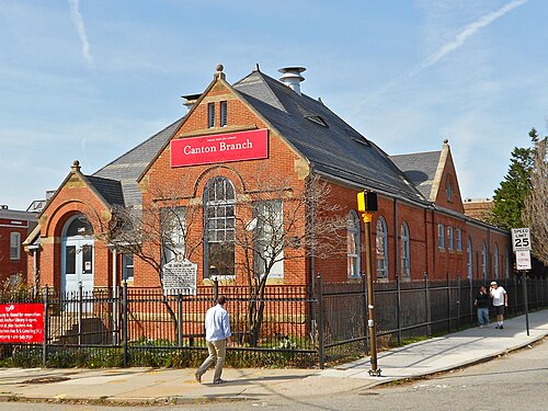 The Enoch Pratt Free Library's Canton Branch on South Ellwood Avenue, red brick with a steep slate roof, arched windows and a Canton Branch sign over the door.