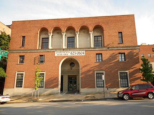 The YMWHA building on West Monument Street, red brick with a large arched entrance and a recessed loggia of columns above.