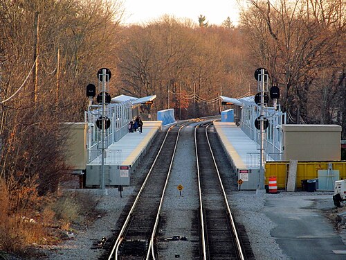 Twin Fairmount Line platforms and tracks at Talbot Avenue station, bare winter trees lining both sides.