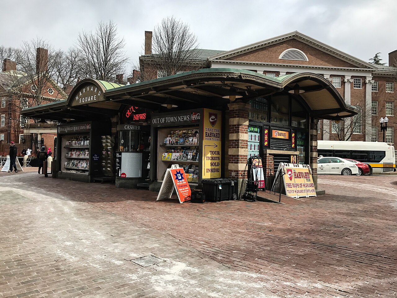The green domed subway kiosk lettered HARVARD SQUARE, the Out of Town News stall open under its awning, a Georgian brick building behind it across the brick plaza.