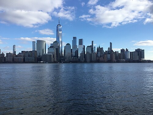 The Manhattan skyline across the Hudson, One World Trade Center at the center, seen from the Jersey City waterfront.