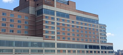 The Hyatt Regency's reddish brown and cream cladding, strip windows and rooftop lettering, on the waterfront.