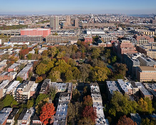A high angle view over the square park and the streets and rowhouses surrounding it.