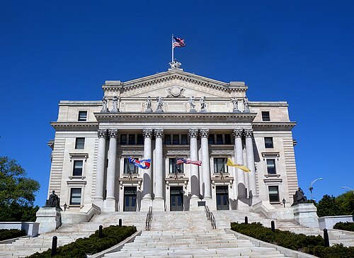 The Essex County Courthouse's Corinthian portico and pediment, flags flying above the steps.
