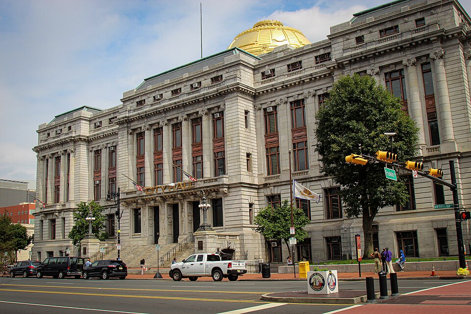 Newark City Hall's limestone facade, CITY HALL lettering over the columned entrance and the gold dome above.