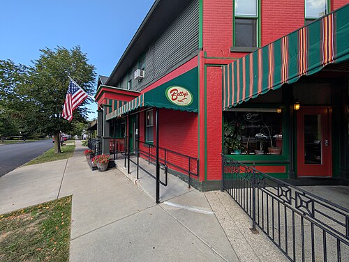 A corner storefront restaurant on Virginia Street, red brick with green trim and a striped awning over the entrance.