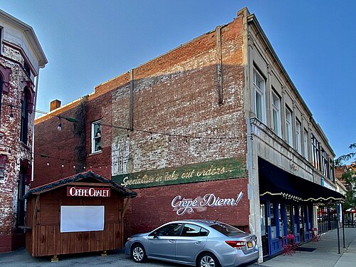 A painted ghost sign for Chin's Chow Mein and the Islander Lounge on a brick side wall on Main Street.