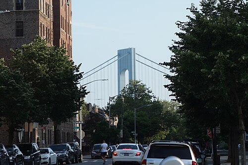 Ridge Boulevard looking south from 86th Street, brick apartment houses along the left and the tower of the Verrazzano-Narrows Bridge at the end of the street.