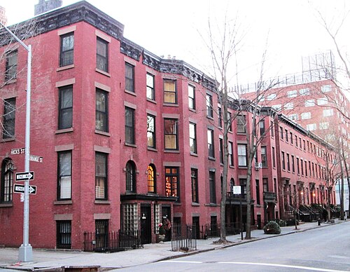 Orange Street at Hicks Street on a winter afternoon, a run of four floor brick houses with iron railings and a bracketed cornice, the row continuing down the block.