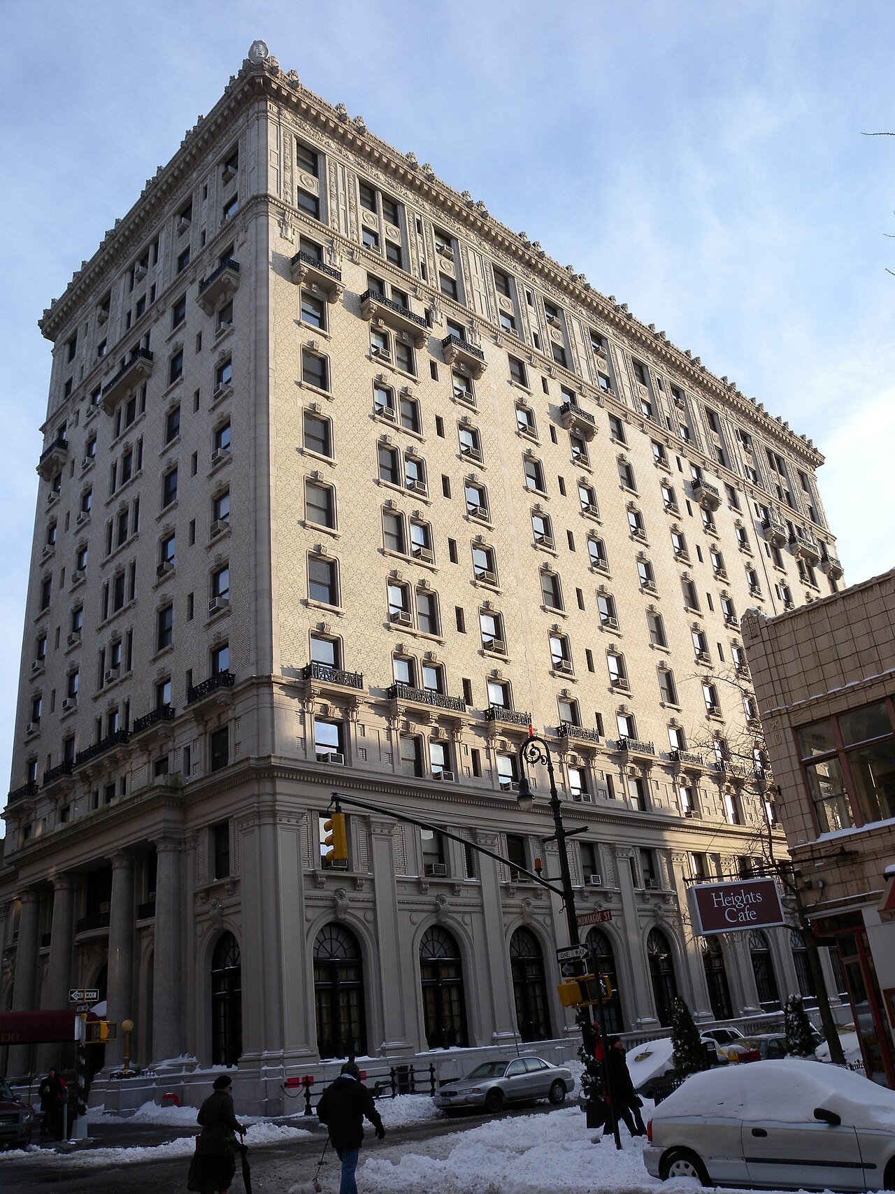 The Hotel Bossert at Hicks Street and Montague Street after snow, a cream terracotta block of thirteen floors with arched shopfronts along the ground.