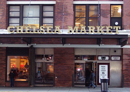 The Ninth Avenue entrance to Chelsea Market, gold lettering across the brick above the doors.