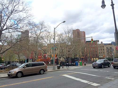 The junction of Worth Street and Baxter Street, where the Five Points met, with the bare trees and playground of Columbus Park behind and an apartment tower beyond that.