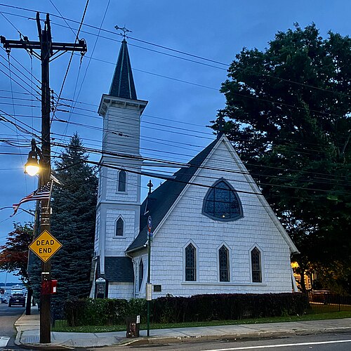Grace Episcopal Church at City Island Avenue and Pilot Street, a shingled Carpenter Gothic church photographed at dusk.