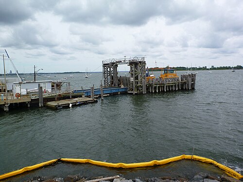 The pier at the foot of Fordham Street, with the small orange ferry that crosses to Hart Island and sailboats moored off the shore.