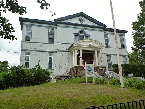 The City Island Nautical Museum on Fordham Street, built as Public School 17 in 1897, with an anchor on the front lawn.