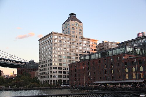 The Clocktower building at dusk over Empire Stores, the Manhattan Bridge at left.