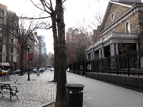 St. Mark's Church in-the-Bowery from Stuyvesant Street on a grey winter afternoon, iron railings and benches along the sidewalk.