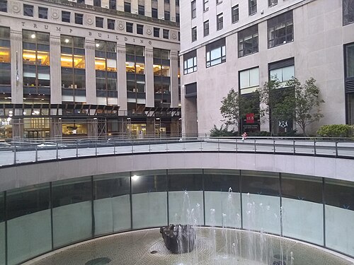 Isamu Noguchi's sunken garden at 28 Liberty Street seen from the plaza rim, with the base of 40 Wall Street across Pine Street behind it.