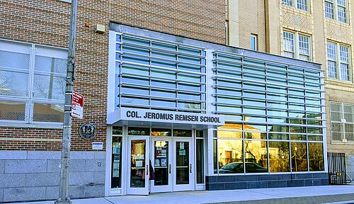 The glass fronted entrance to the Col. Jeromus Remsen School, its name in metal letters above the doors.