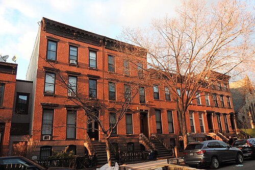 Brick and brownstone row houses on Kent Street in low golden hour sun.
