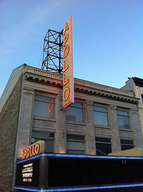 The Apollo neon blade sign lit at dusk over 125th Street.