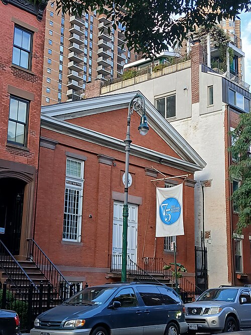 The Actors Studio at 432 West 44th Street, the pedimented brick front of an 1850s church with a banner hung off it and an apartment tower behind.