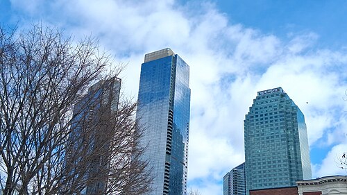 Towers at Court Square seen from below, one in blue glass and one with a stepped green crown.
