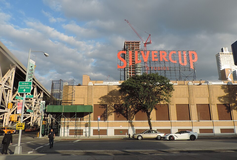 The Silvercup sign on the roof of the old bakery at 21st Street, with the Queensboro Bridge ramp at the left and a tower crane behind it.
