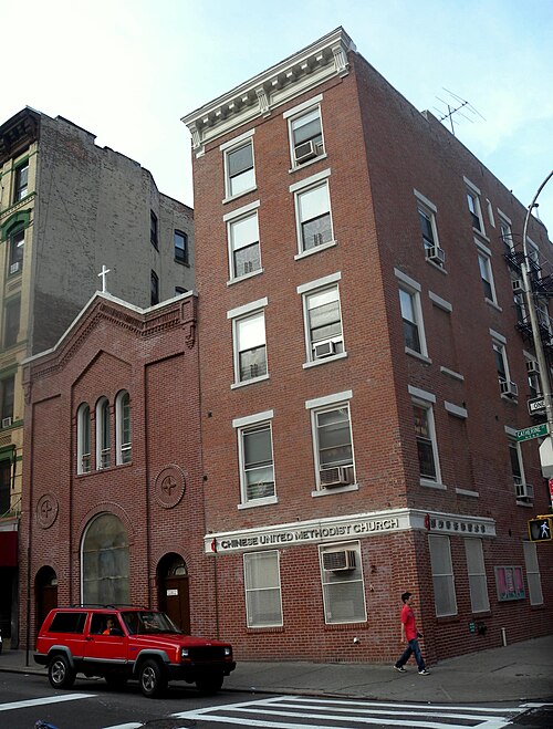 The Chinese United Methodist Church on the corner of Catherine Street and Madison Street, a small brick chapel beside a four storey brick corner building on a partly sunny afternoon.