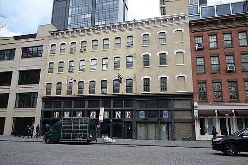 A five storey painted masonry building at 407 to 411 West 14th Street, empty storefronts at street level, Belgian block visible in the road.
