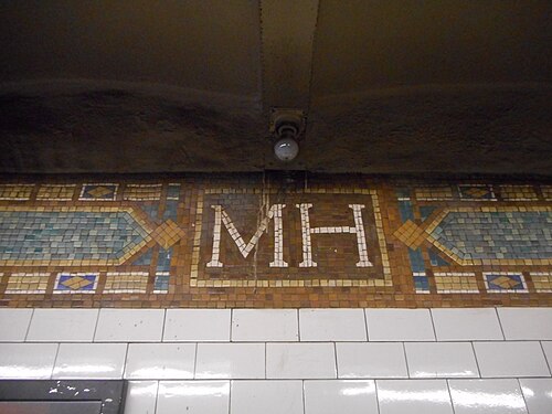 The tiled MH monogram on the platform wall at the 138th Street subway station on the Grand Concourse.